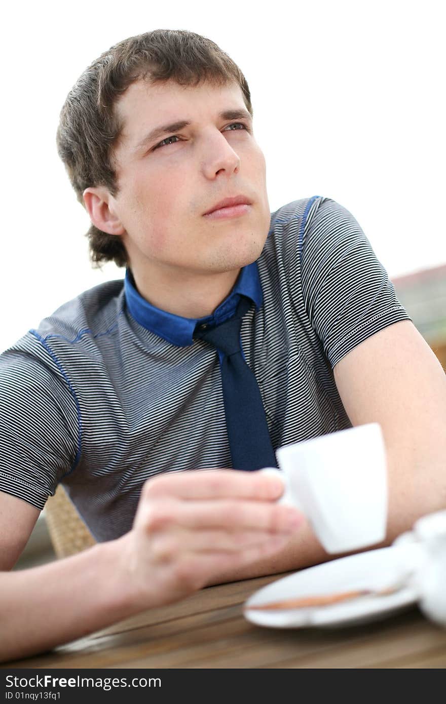 Young man drinks coffee outside. Young man drinks coffee outside.