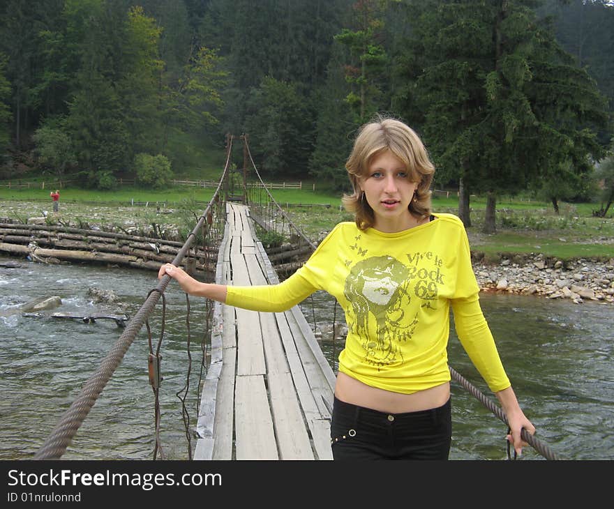 Beautiful girl on a bridge in a yellow blouse