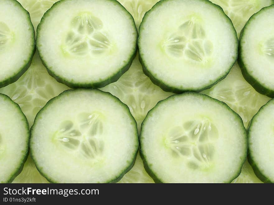 Many cucumber slices filling the frame to create a background. Many cucumber slices filling the frame to create a background.