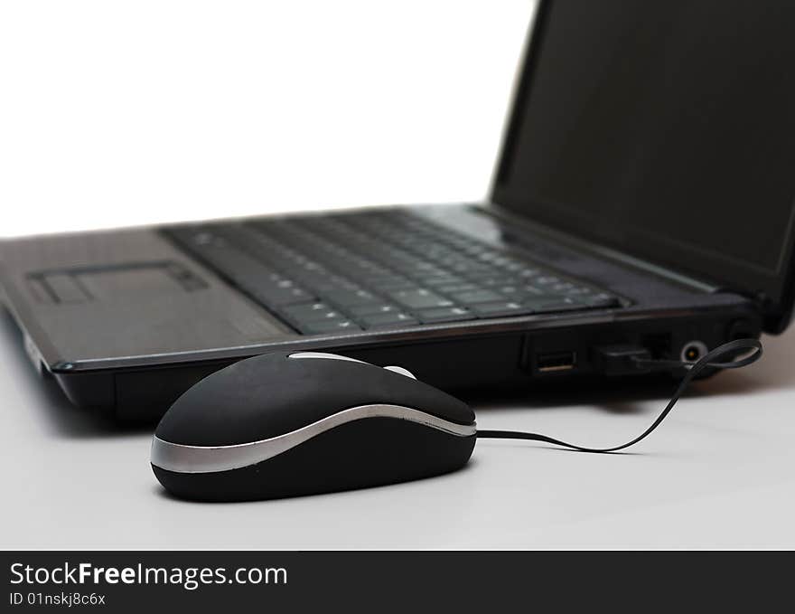 A laptop computer with an attached mouse