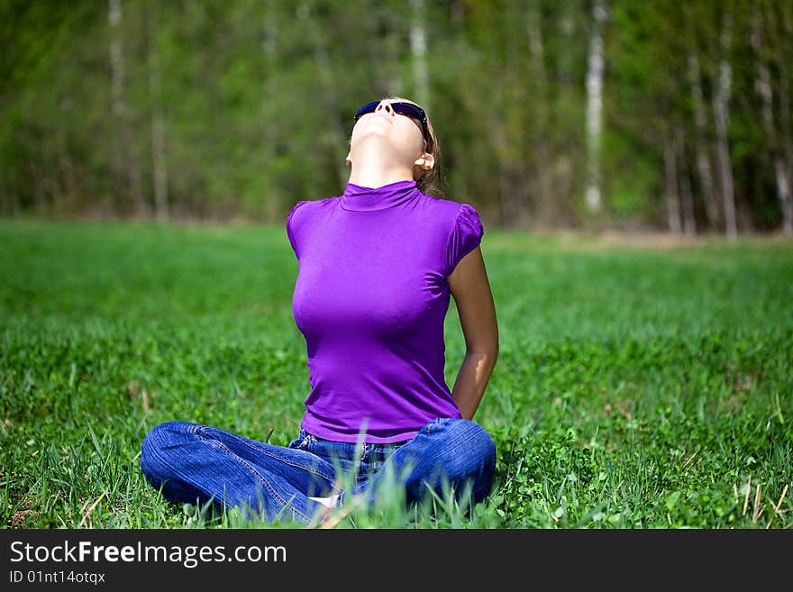 Beautiful woman sitting in the grass and Enjoy the sun. Beautiful woman sitting in the grass and Enjoy the sun