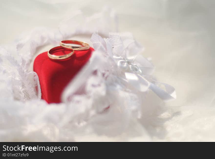 Gold wedding rings lying on a red jewelry box