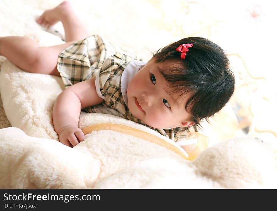 A baby girl on her belly on a big teddy bear