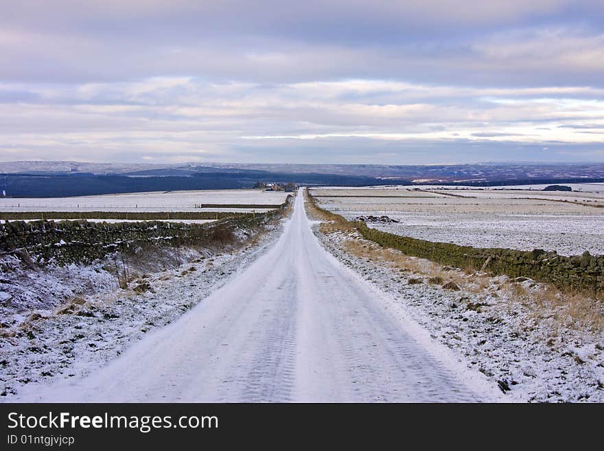 Deserted road across snow-covered moorland in the depths of winter. Deserted road across snow-covered moorland in the depths of winter