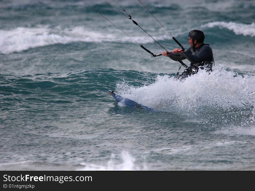 Kitesurfer surfing through the waves