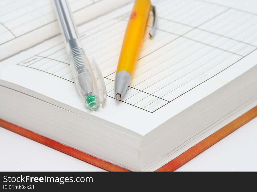 Notebook and pens on a white background