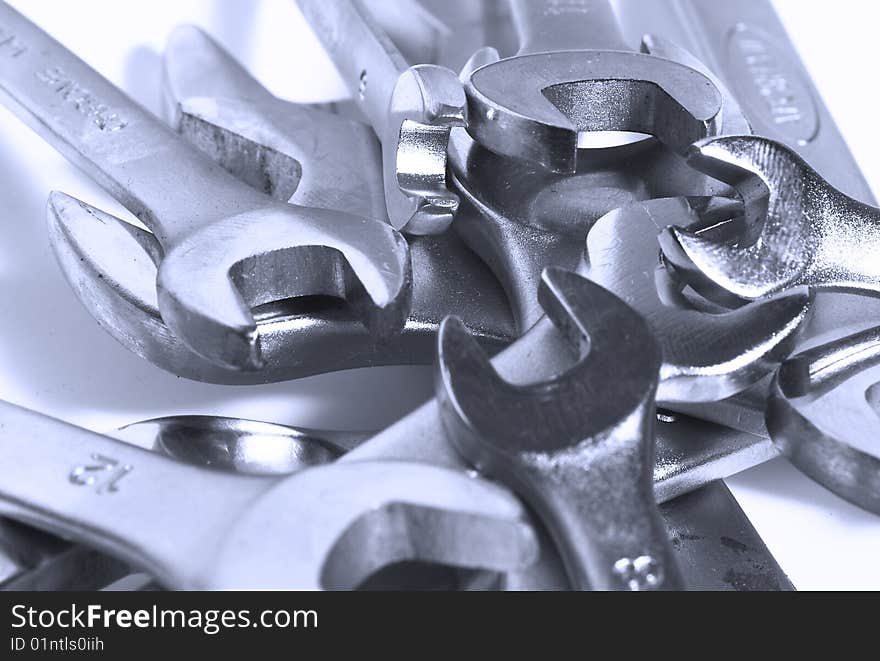 Set of wrenches piled up in blue light