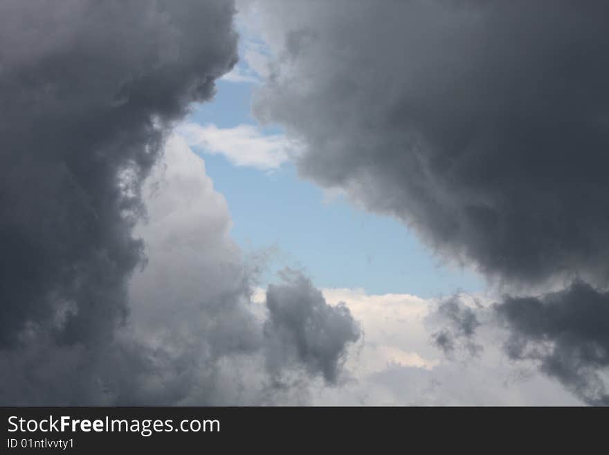 Dark clouds over a bright and sunny day. storm is brewing. Dark clouds over a bright and sunny day. storm is brewing..