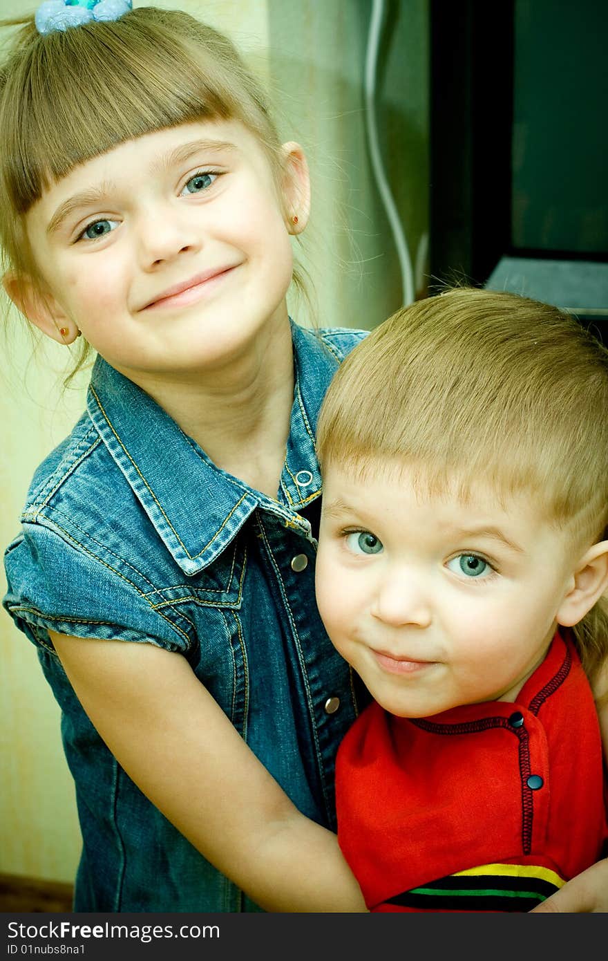 Two siblings embrace each other and laughing happily.