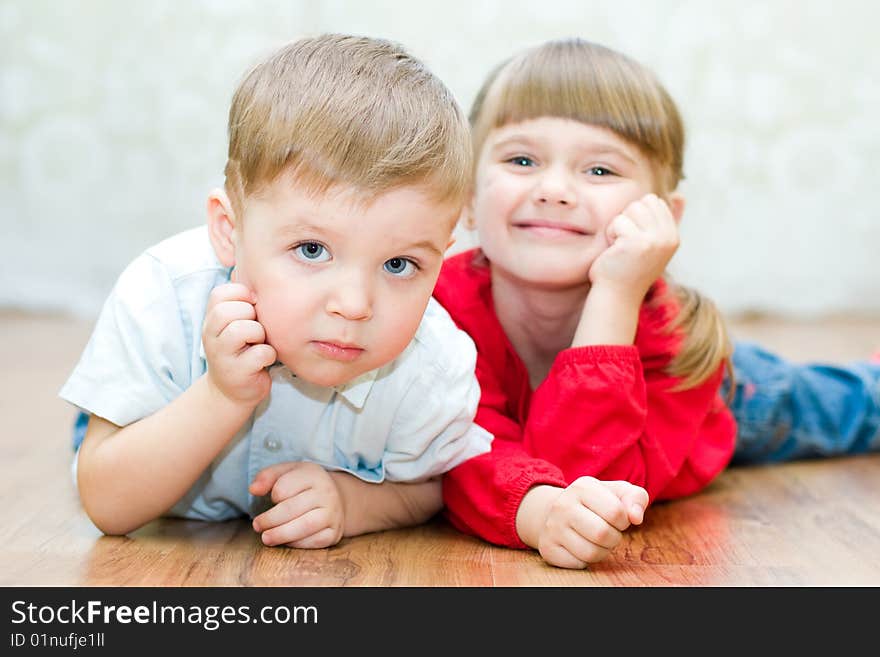 Funny boy and a girl lying on the floor