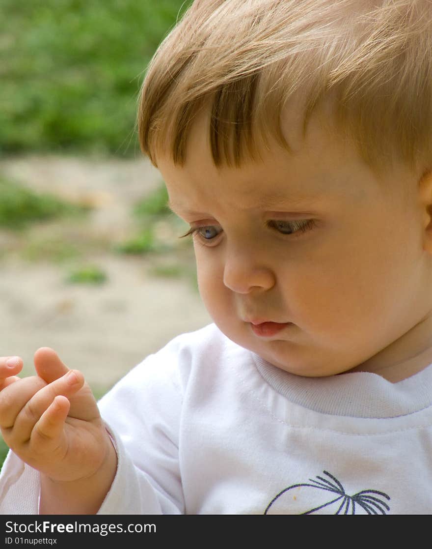 Serious baby-boy in white t-shirt on walk