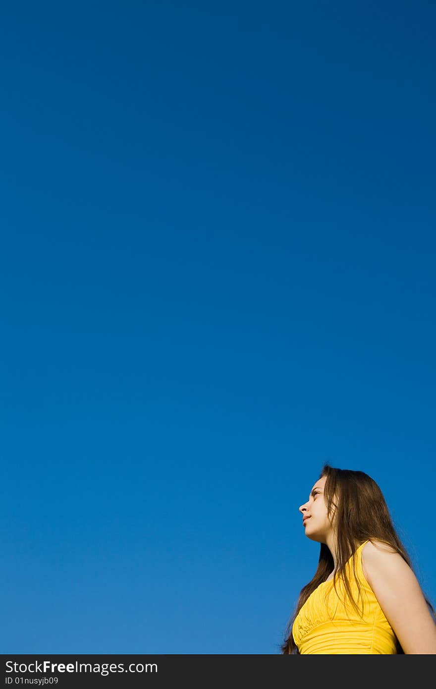 A young girl in yellow looking to the sky