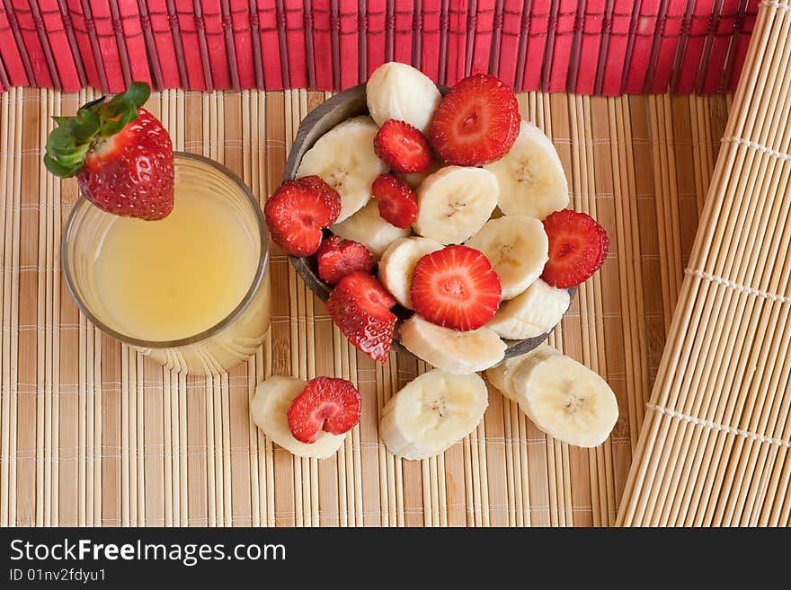 Tropic lunch: cut bananas and strawberries served in a coconut and a glass of juice (2). Tropic lunch: cut bananas and strawberries served in a coconut and a glass of juice (2)