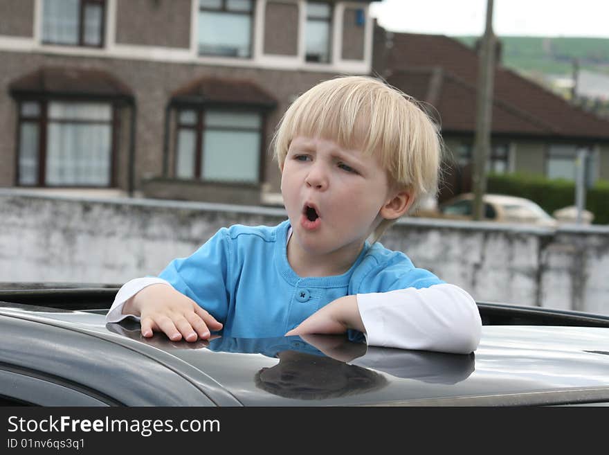 Boy in the car climbing the sun roof