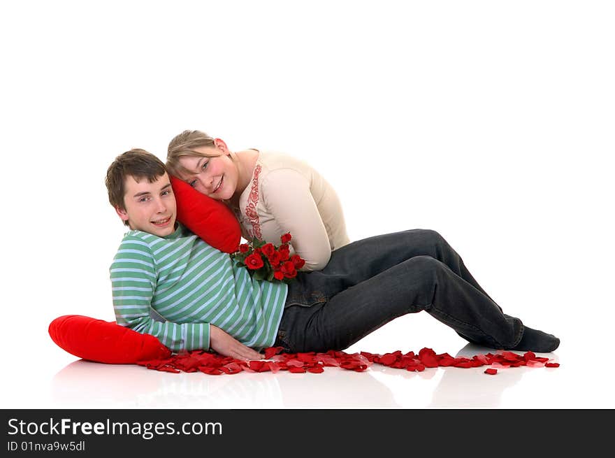 Two casual dressed teenagers, teenage man and woman in love, surrounded with rose petals. studio shot. Two casual dressed teenagers, teenage man and woman in love, surrounded with rose petals. studio shot.