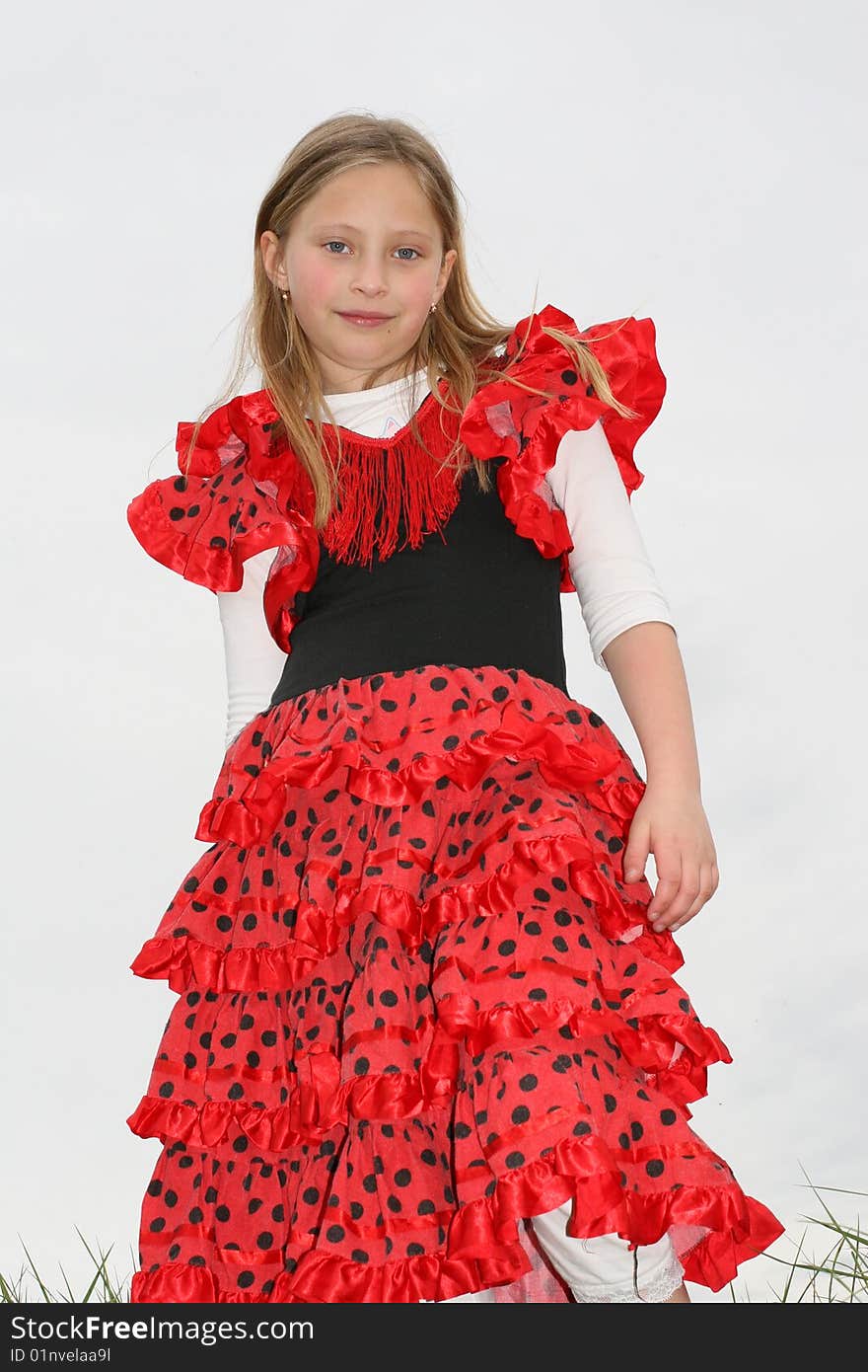 Small girl in red dress posing on the grass. Small girl in red dress posing on the grass