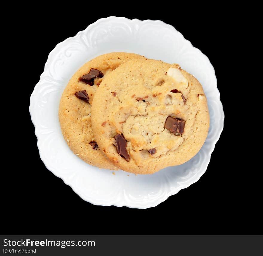 Chocolate chip cookies on a white plate on a black background. Chocolate chip cookies on a white plate on a black background.