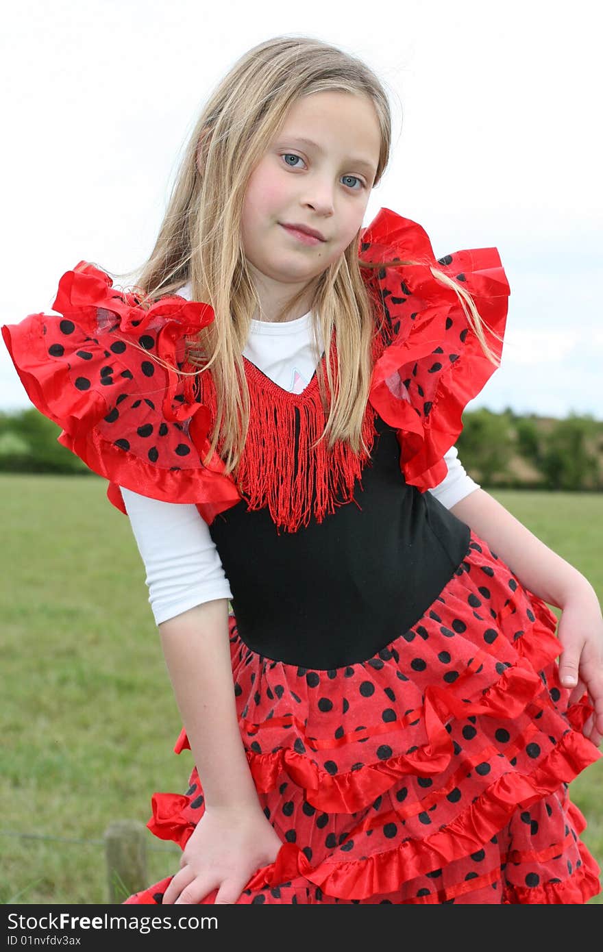 Small girl in red dress posing on the grass. Small girl in red dress posing on the grass