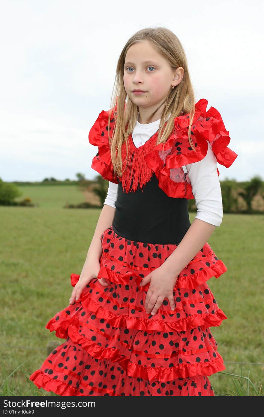 Small girl in red dress posing on the grass. Small girl in red dress posing on the grass