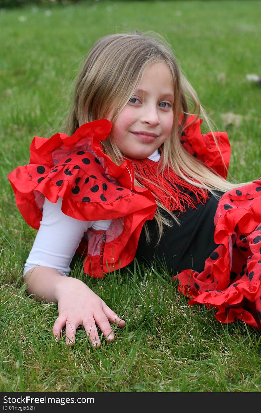 Small girl in red dress posing on the grass. Small girl in red dress posing on the grass