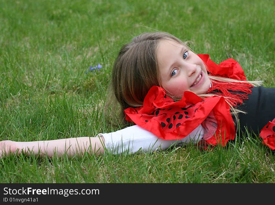 Small girl in red dress posing on the grass. Small girl in red dress posing on the grass