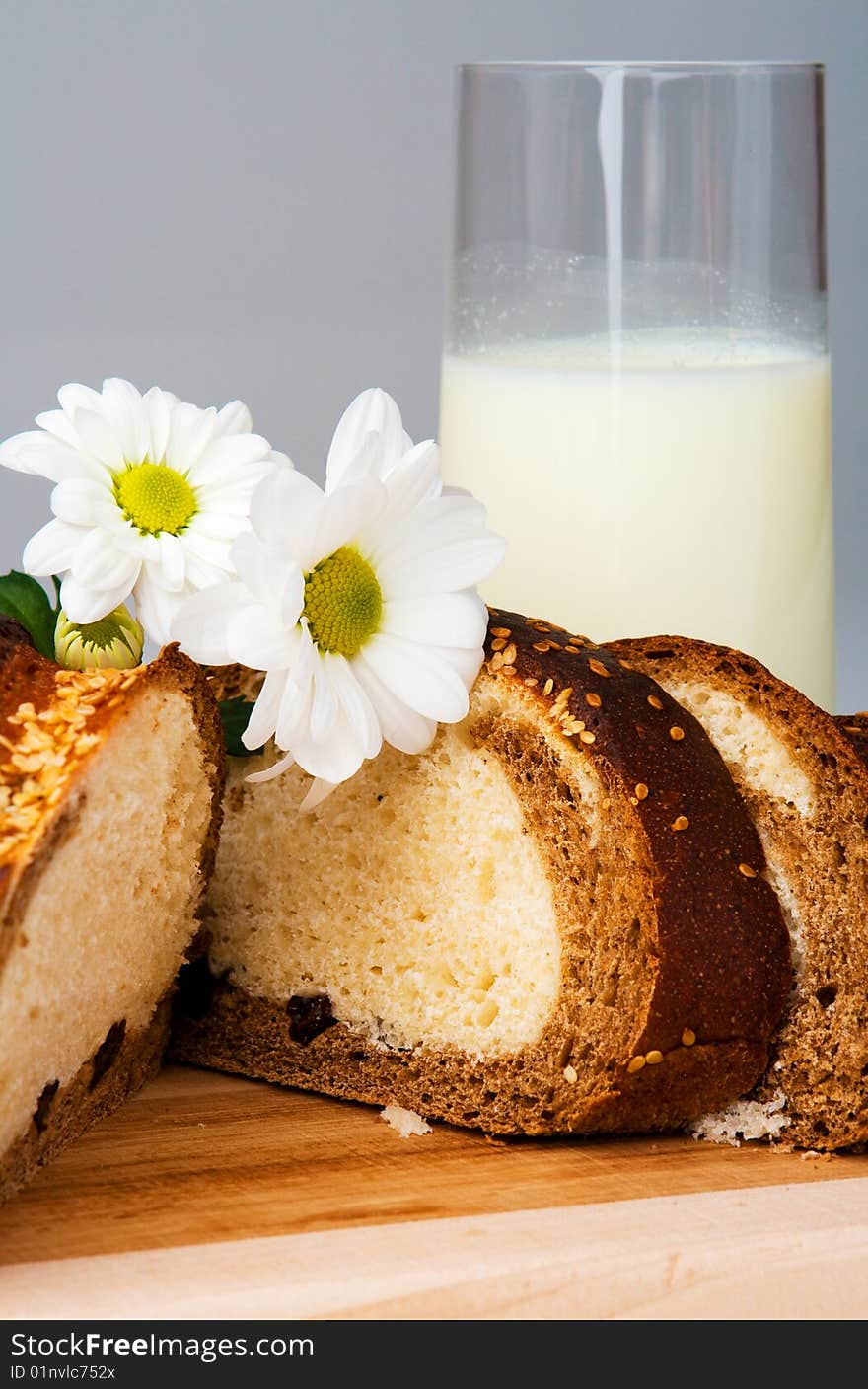 Sliced bread, milk and flowers on gray. Sliced bread, milk and flowers on gray