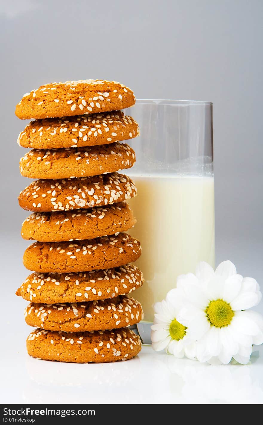 Biscuits in stack and milk glass, on grey. Biscuits in stack and milk glass, on grey