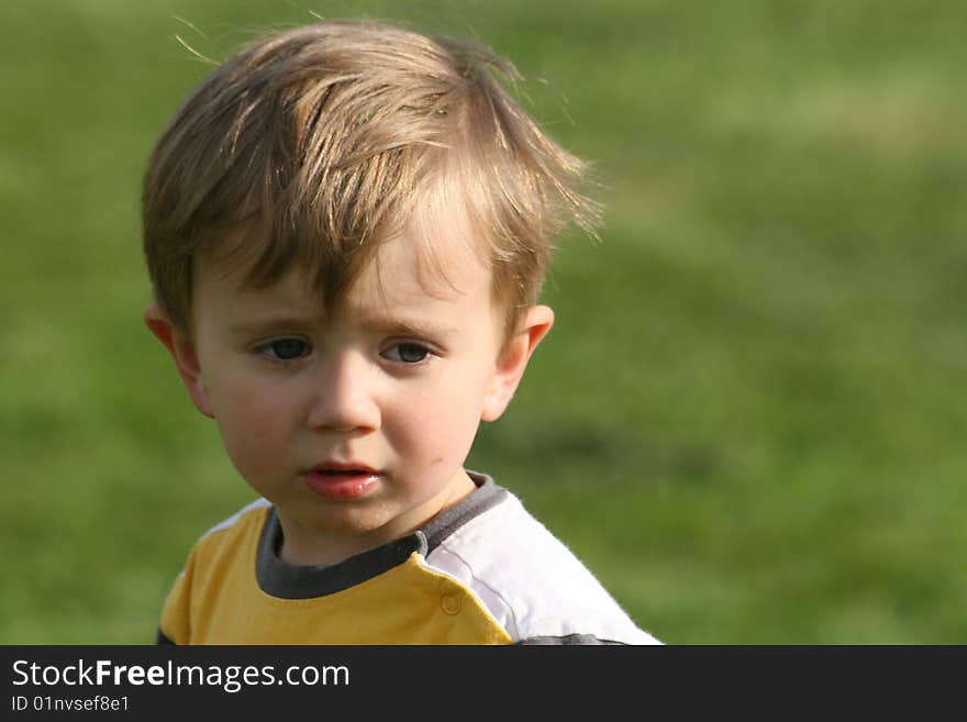 Small boy on the pitch, concentration visible on the face. Small boy on the pitch, concentration visible on the face