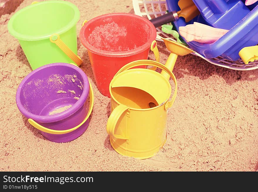 A collection of childrens buckets on a sandy beach. A collection of childrens buckets on a sandy beach