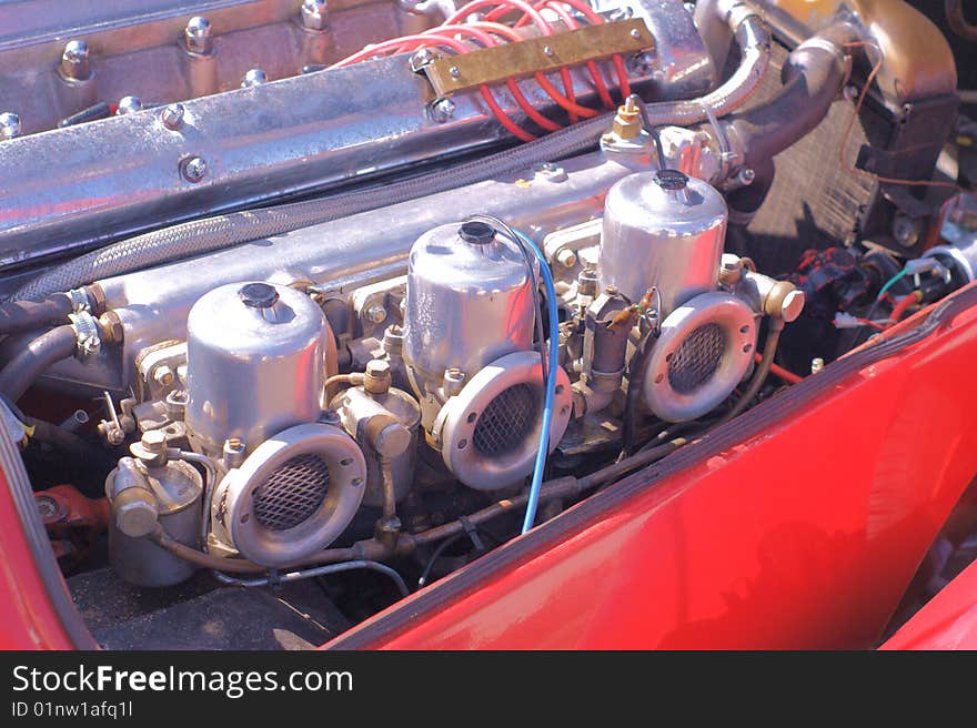 Showing the triple carburetors on an old sports car. Showing the triple carburetors on an old sports car