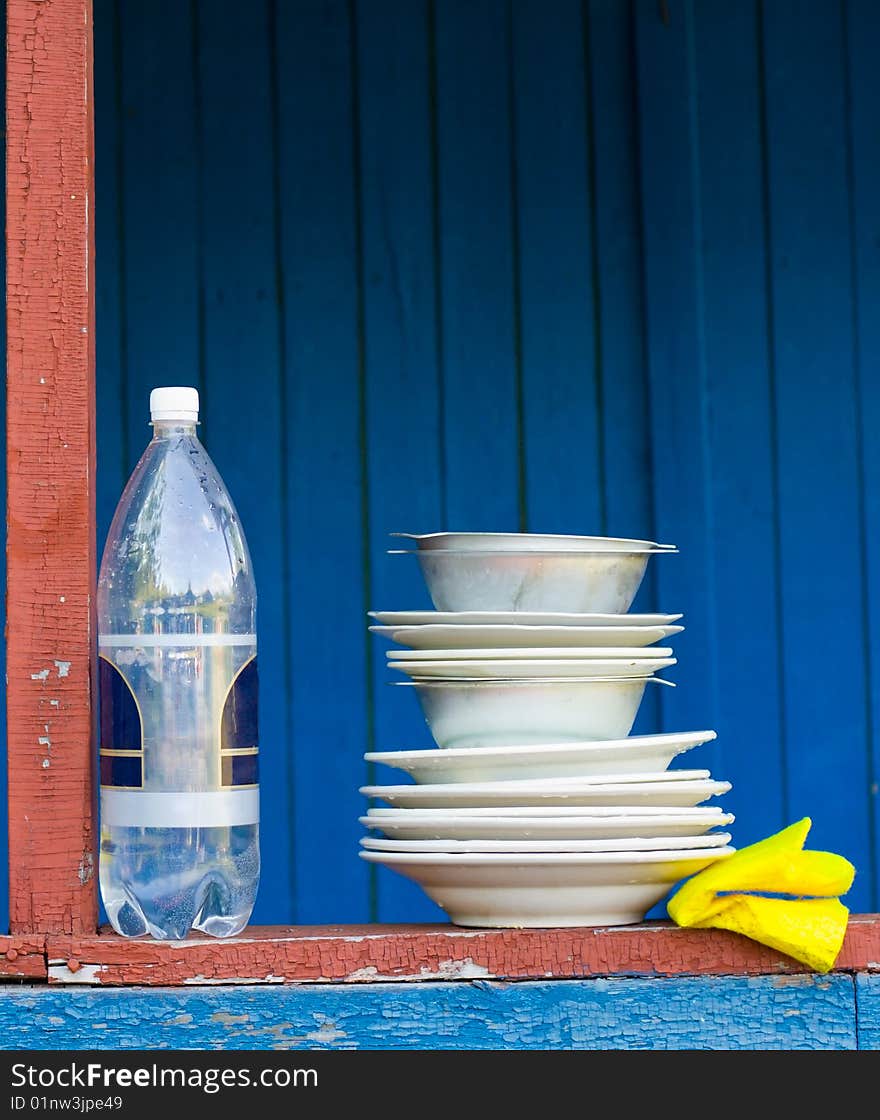 Plates and bottle of water on a wooden shelf. Plates and bottle of water on a wooden shelf