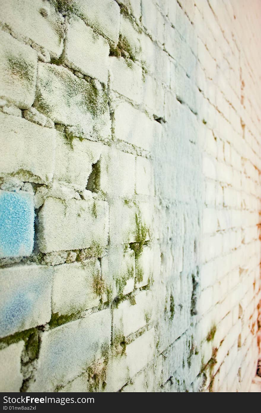 Old brick wall covered by a layer of frozen water