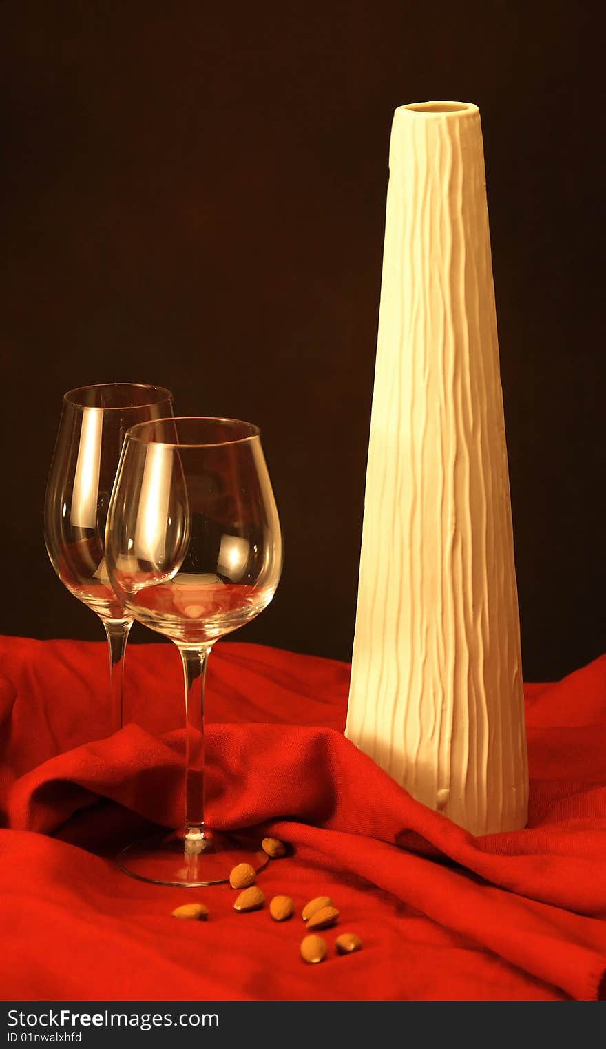 Red wine glasses with vase and almonds on the table waiting for filling. Red wine glasses with vase and almonds on the table waiting for filling