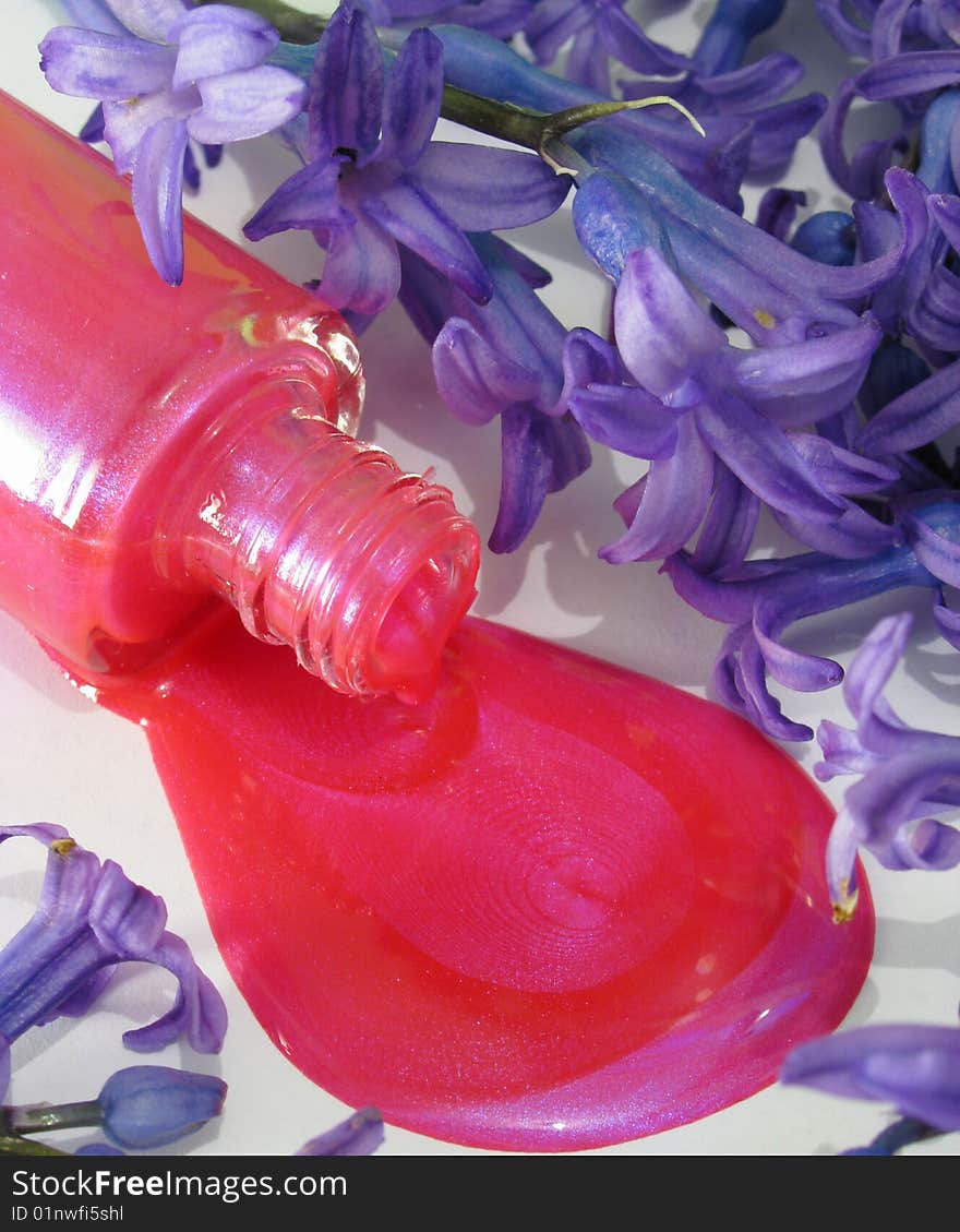 Spilled pink nail polish and purple flowers