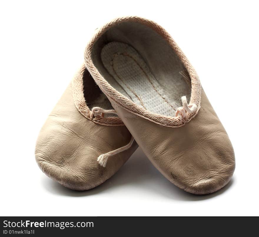 A pair of used child's ballet shoes isolated on a white background