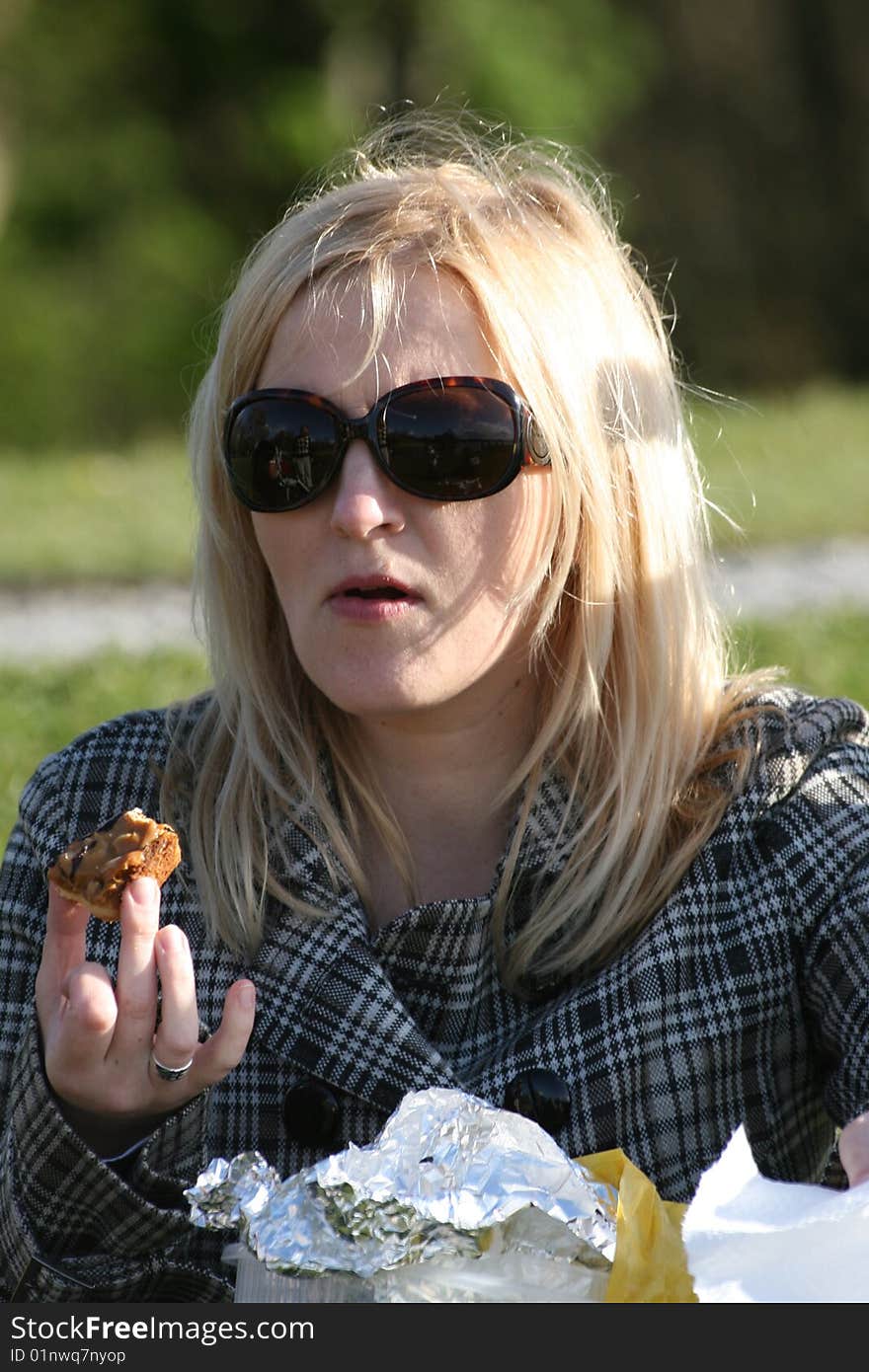 Quick lunch outdoor, woman is eating cake. Quick lunch outdoor, woman is eating cake