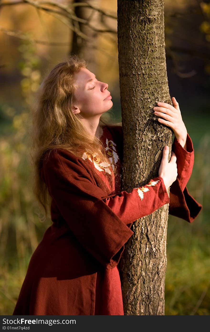 The blonde girl in medieval red dress in the autumn forest. The blonde girl in medieval red dress in the autumn forest