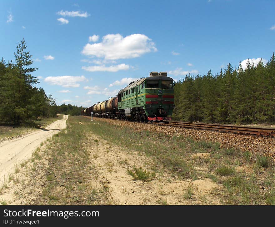 Cargo train diesel locomotive in the pine forest. 
Ukraine. May 2009. Cargo train diesel locomotive in the pine forest. 
Ukraine. May 2009.