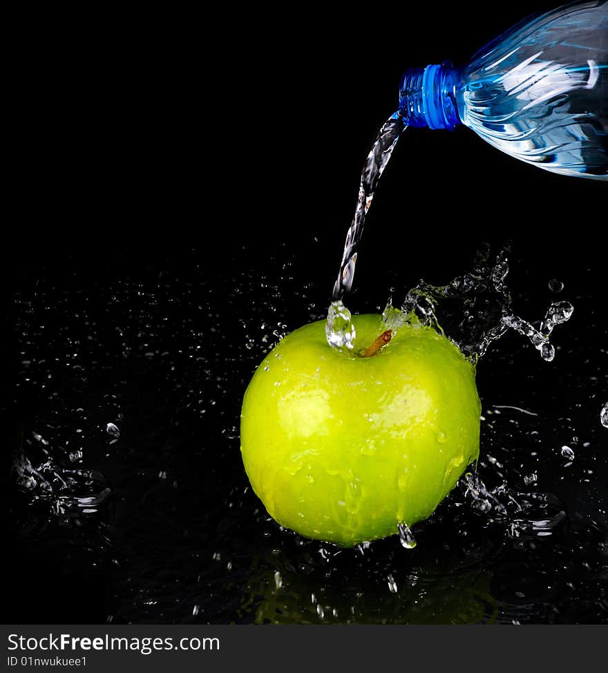 Fresh water splash on green apple on black background