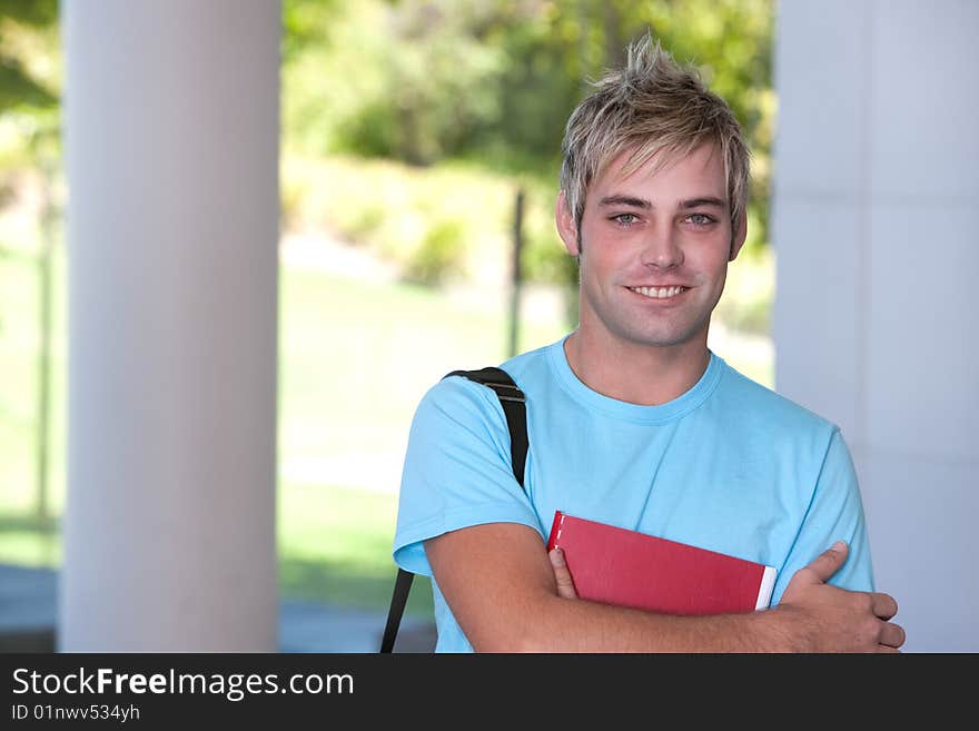 Portrait of male student holding a book.