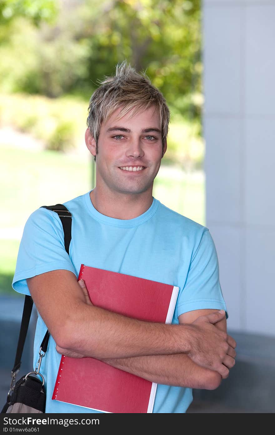 Portrait of male student holding a book.