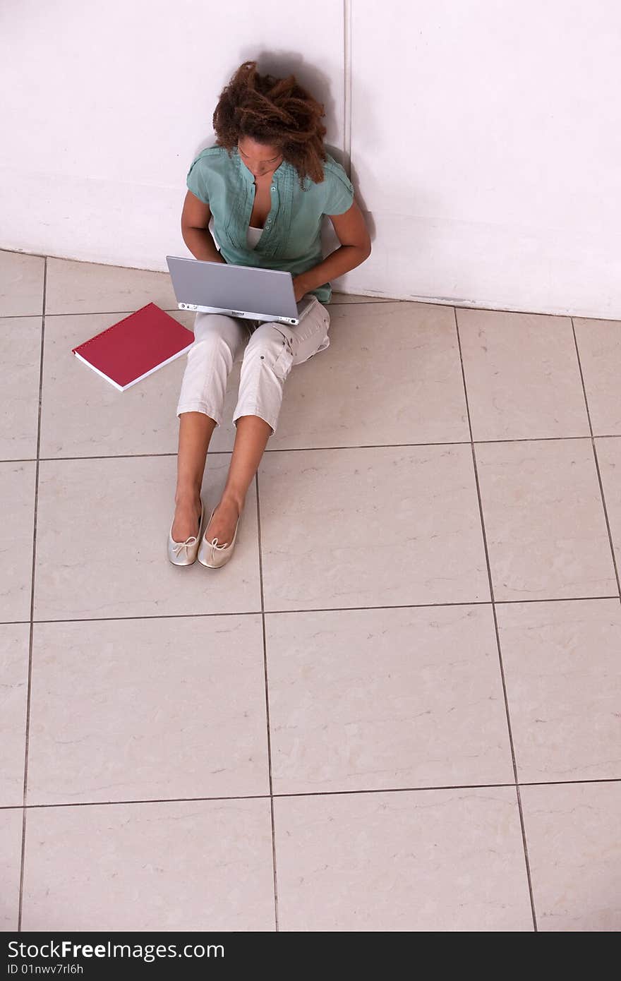 Student sitting on floor doing homework. Student sitting on floor doing homework.