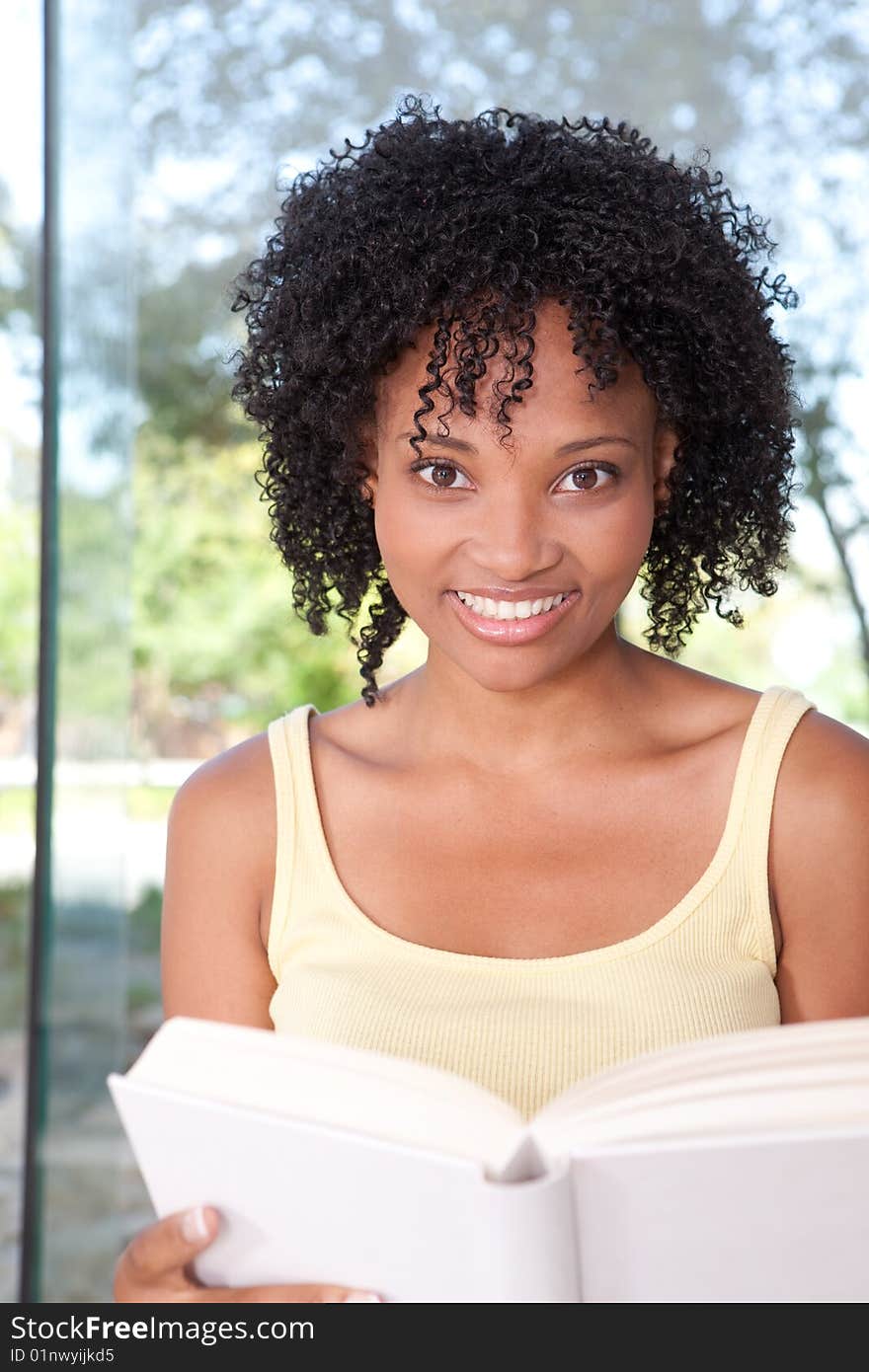 Portrait of female student reading a book.