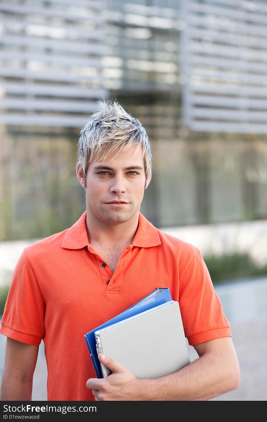 Portrait of male student holding files.