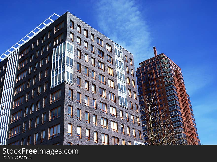 Two large buildings against a blue sky. Two large buildings against a blue sky.