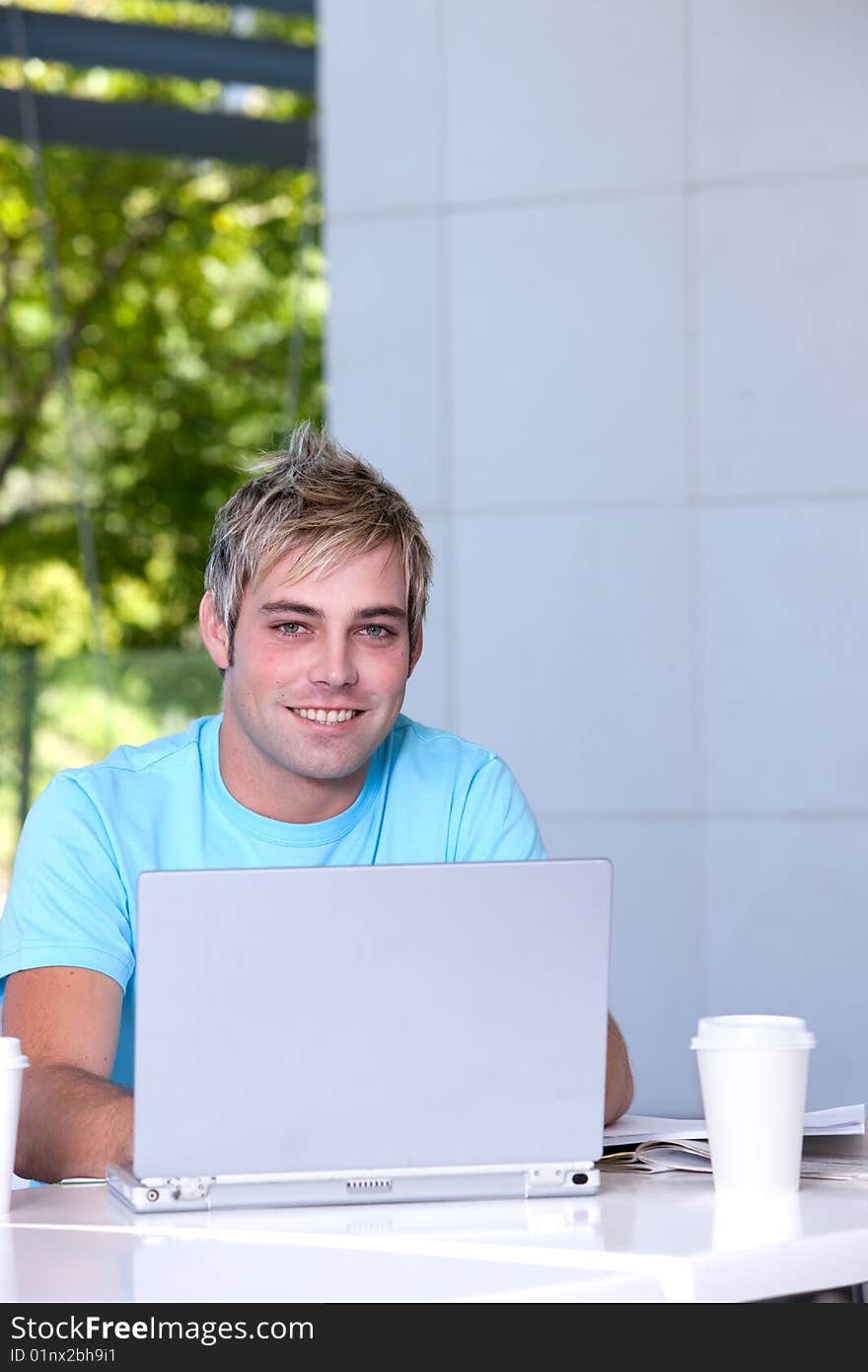 Portrait of male student working on laptop.