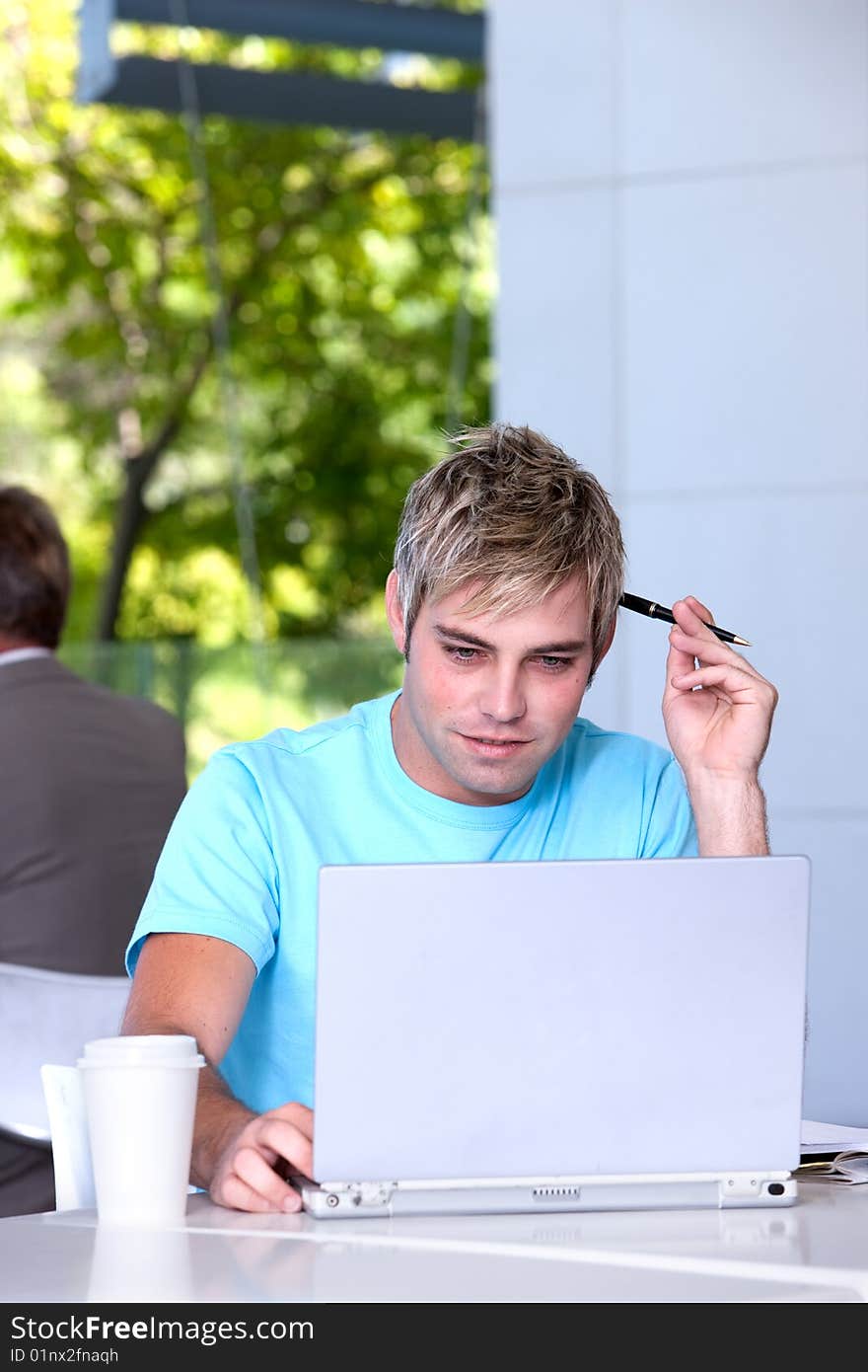 Portrait of male student working on laptop. Portrait of male student working on laptop.