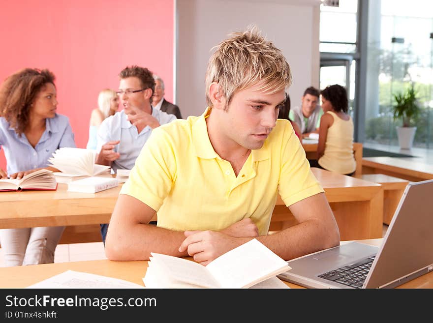 Portrait of male student working on laptop.