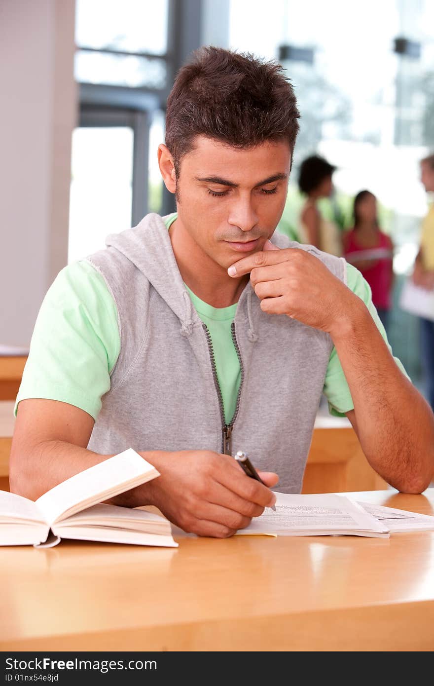 Portrait of male student sitting at desk.