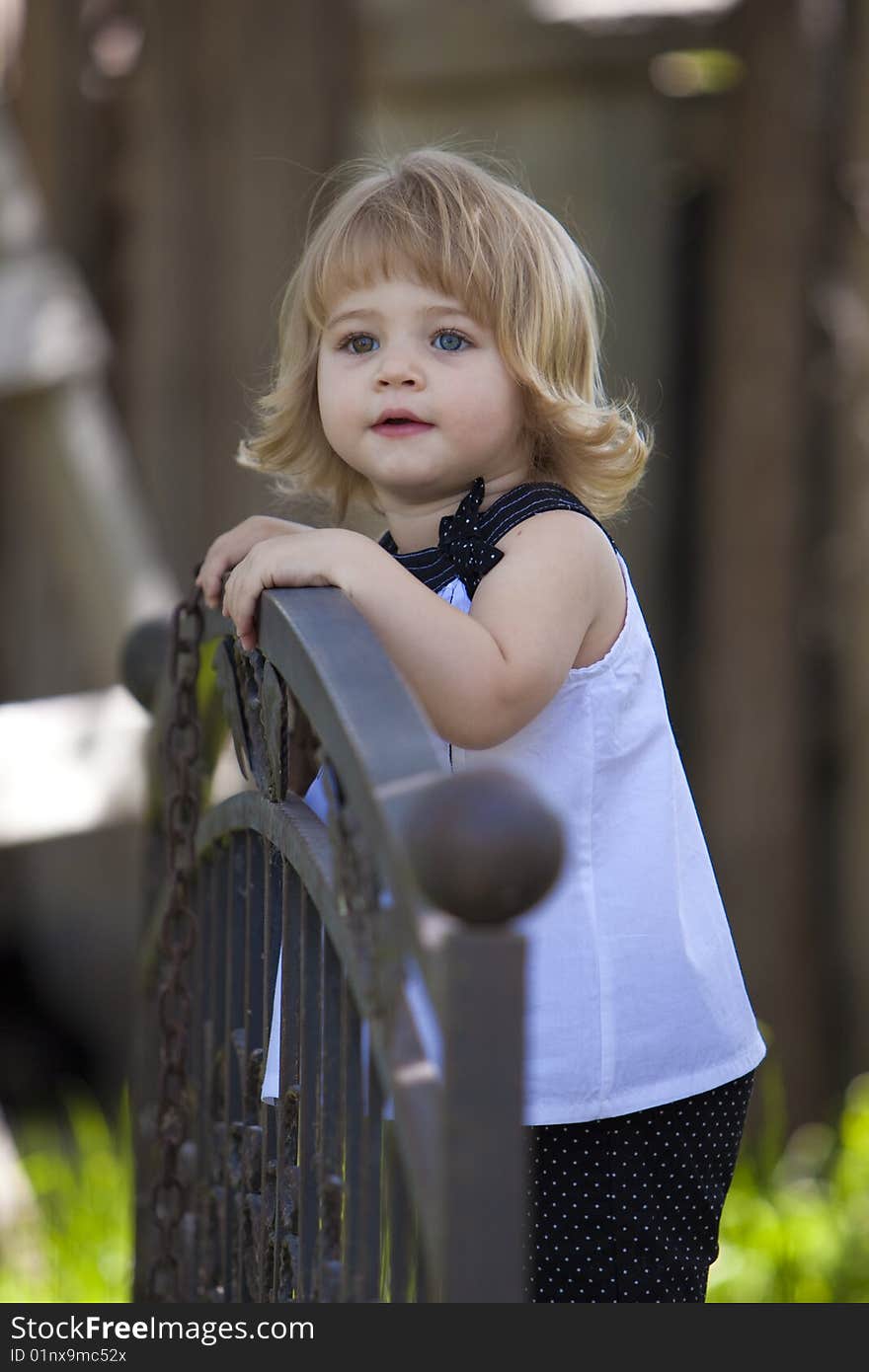 Little girl standing on bridge in white top. Little girl standing on bridge in white top